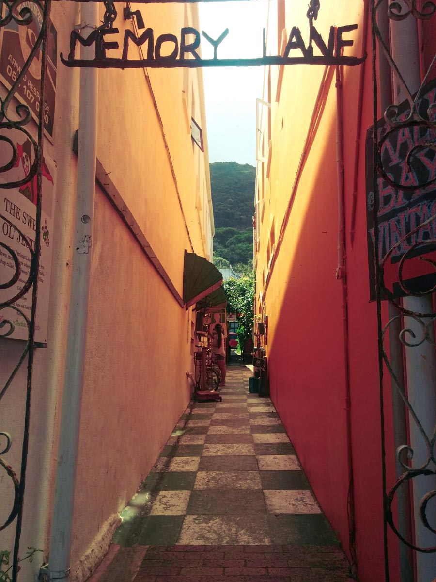 a charming alleyway in old town kalk bay with checkered tiles and orange walls