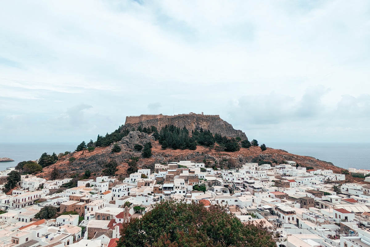 a view of the lindos acropolis surrounded by white houses and buildings