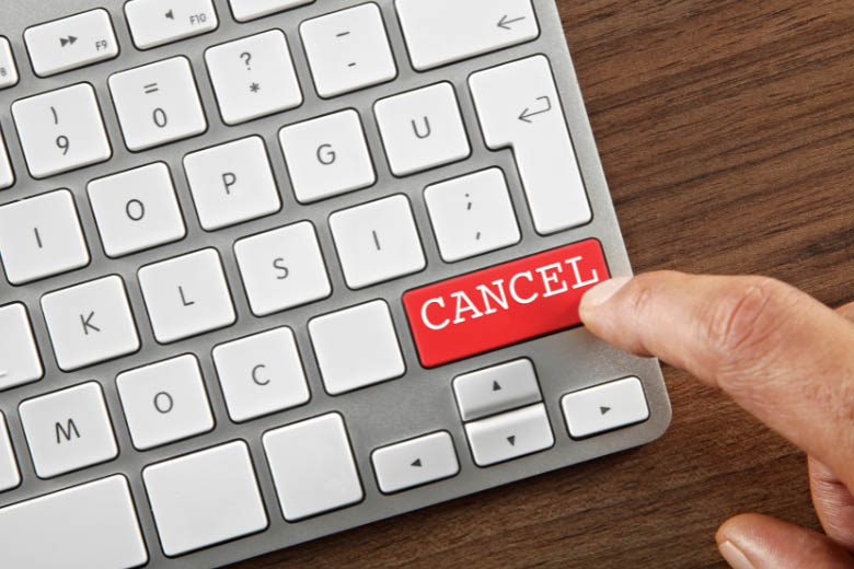 a person with their finger on the cancel button of a keyboard