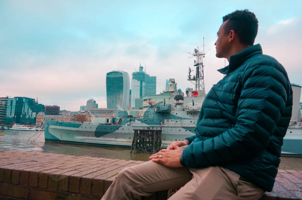 man looking across thames river contemplating the costs of living in London