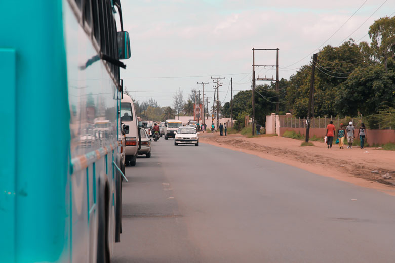 the EN2 road from Matola to Maputo congested with buses and cars, and people walking on the sidewalk