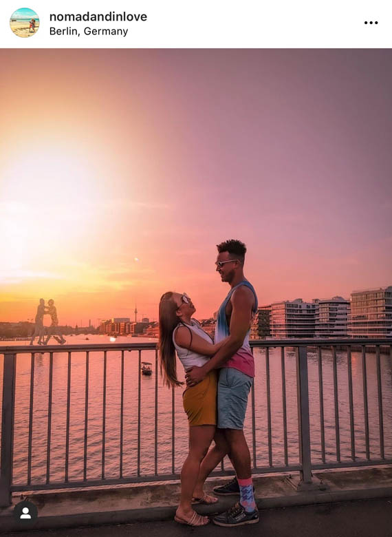 pink and orange sunset photography of a couple taken on elsen bridge in berlin germany