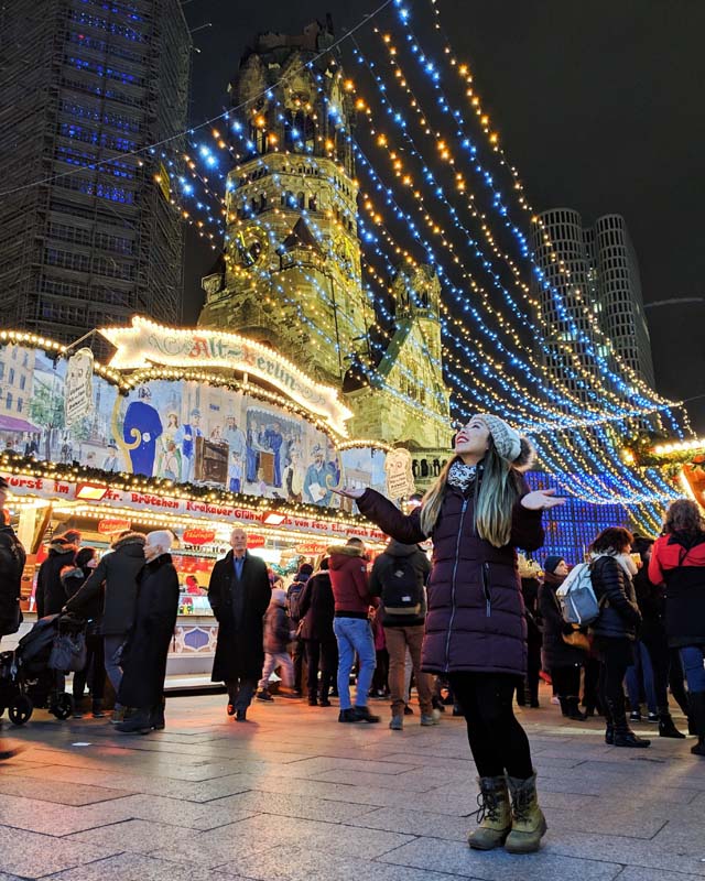 a woman admiring Christmas lights at the Breitscheidplatz Christmas Market in Kurfürstendamm