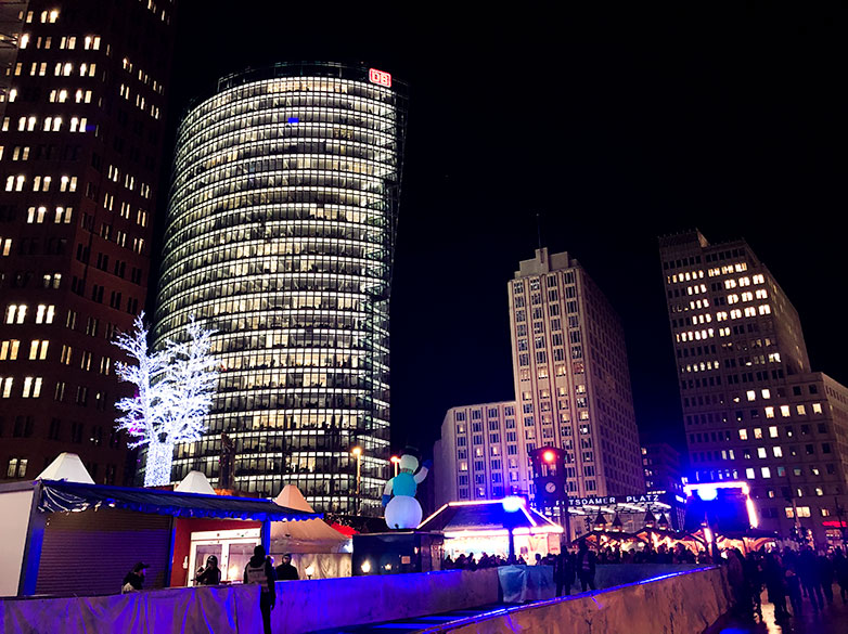 winter world at potsdamerplatz christmas market in berlin with deutsche bahn office building in the background