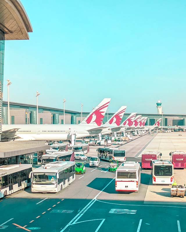 Qatar Airways planes lined up on the ramp outside a terminal at Hamad International Airport waiting for passengers to embark who are transiting to Berlin Germany