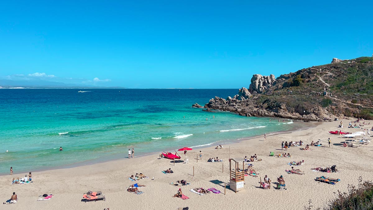 a white sandy beach with crystal clear turquiose blue waters in the most northern tip of sardinia island italy