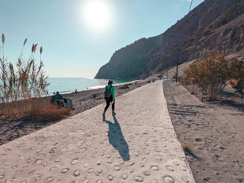 a woman wearing hiking shoes carrying a backpack at agia roumeli in south crete