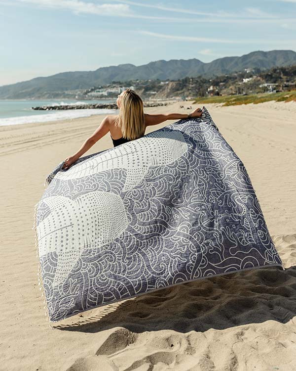 women holding a eco-friendly sand cloud beach towel with whale shark design