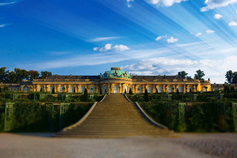 sanssouci palace or schloss sanssouci in sanssouci park during summer with sun rays in the blue sky