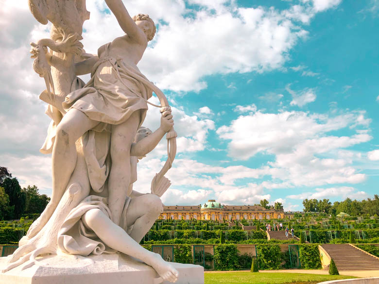 beautiful white sculpture with potsdam sanssouci palace in the distance