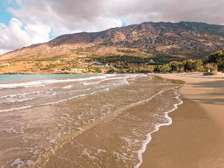 a off the beaten track, quiet beach in east crete called tholos beach with mountains in the backdrop