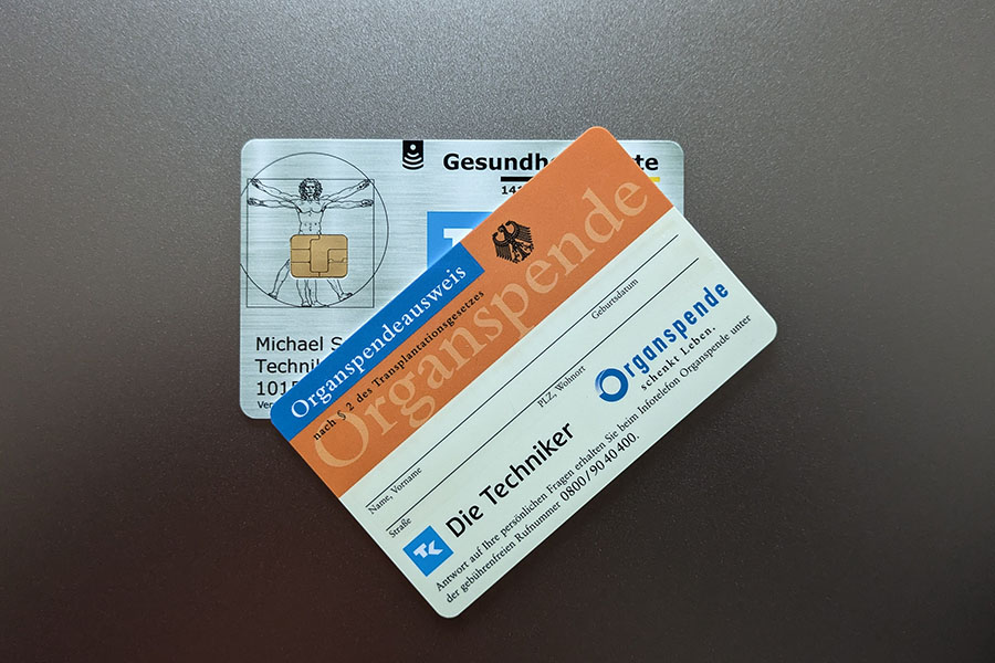 a German organ donor card overlapping a Techniker Krankenkasse (TK) public health insurance card, giving you access to Germany’s public healthcare system