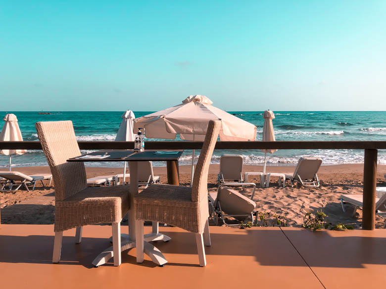a beachfront hotel in crete including breakfast with sun loungers and umbrellas on the white sand