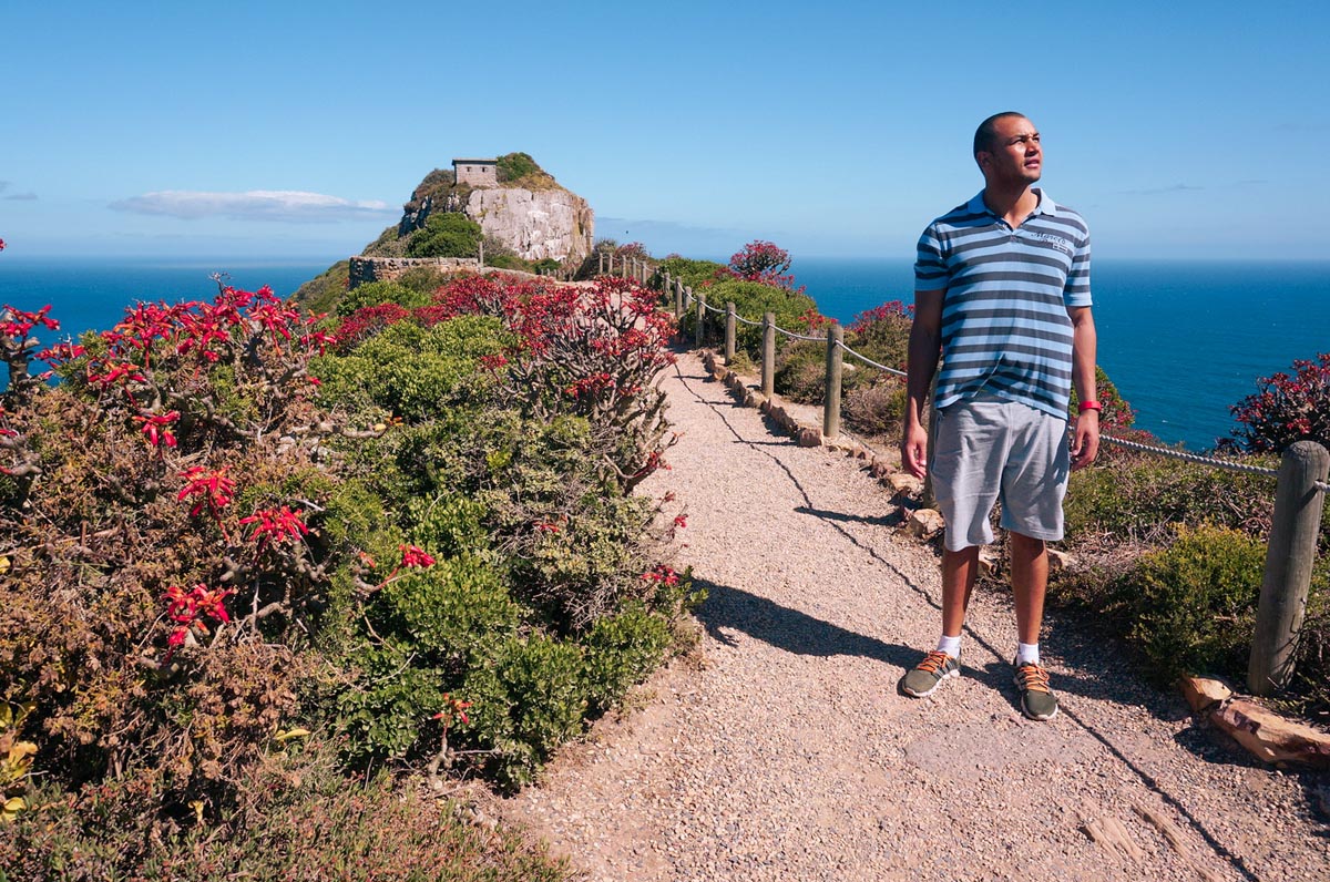 a man hiking to the lighthouse at cape point national park in south africa