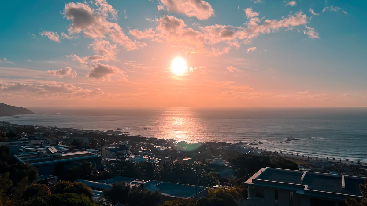 orange sunset over camps bay beach in south africa