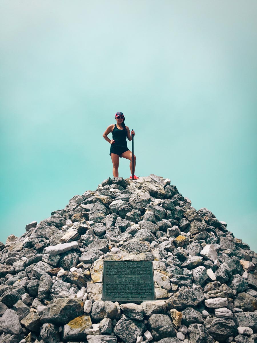 a hiker standing at the highest point of table mountain maclear's beacon on the platteklip gorge hiking trail 