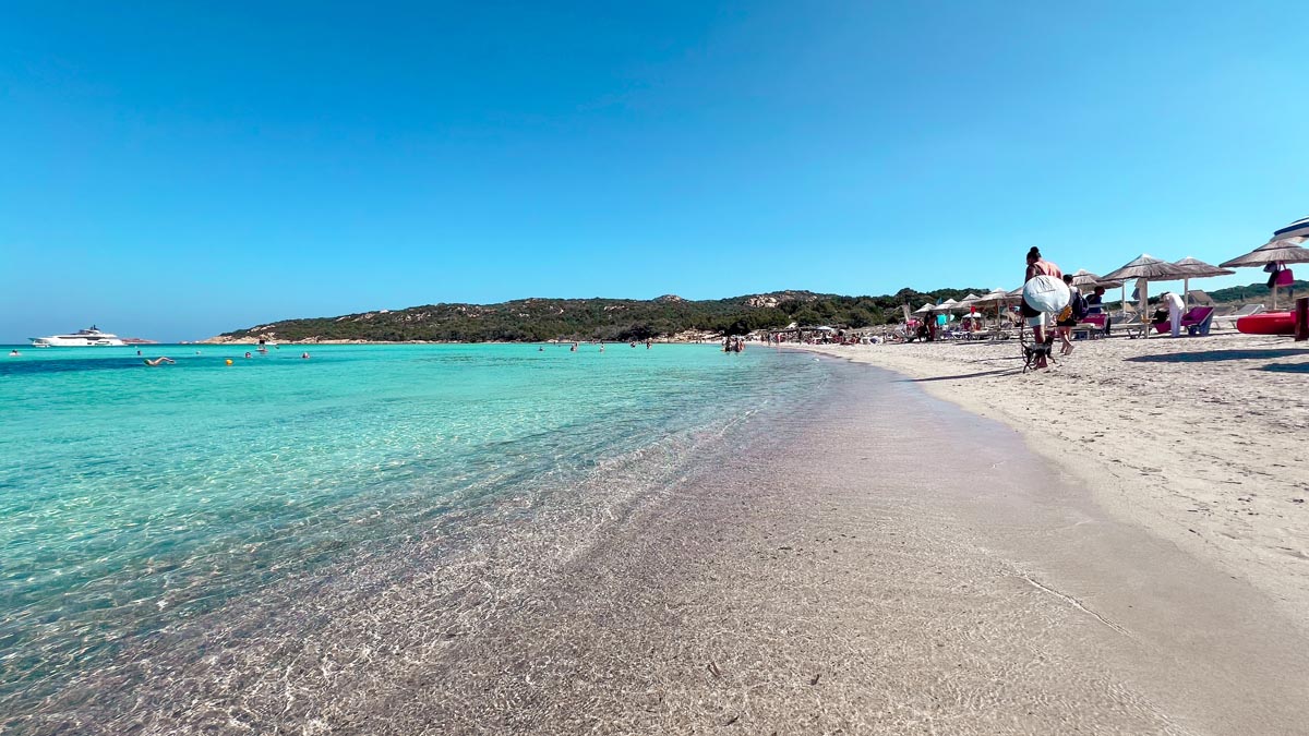 a beach with crystal clear turquoise blue waters along costa smeralda coast in north east sardinia