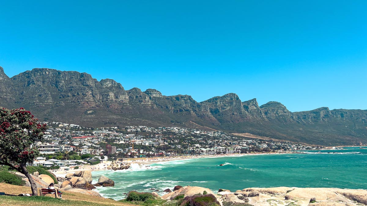 a view of camps bay beach on the atlantic seaboard of cape town with holiday apartments and houses dotted on the 12 apostles mountains