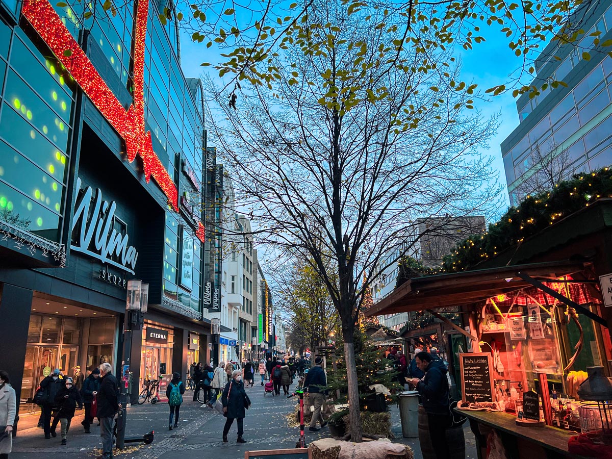 locals shopping in wilmersdorferstrass in charlottenburg berlin with christmas market stalls lining the street opposite wilma shopping centre