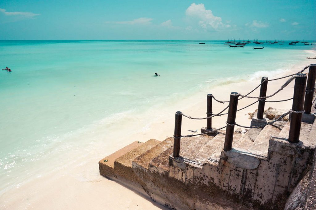 cement stairs leading onto the best beach in zanzibar island tanzania with its pristine turquoise blue waters and white sand